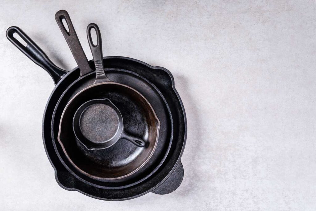 Stack of cast iron pans on grey countertop