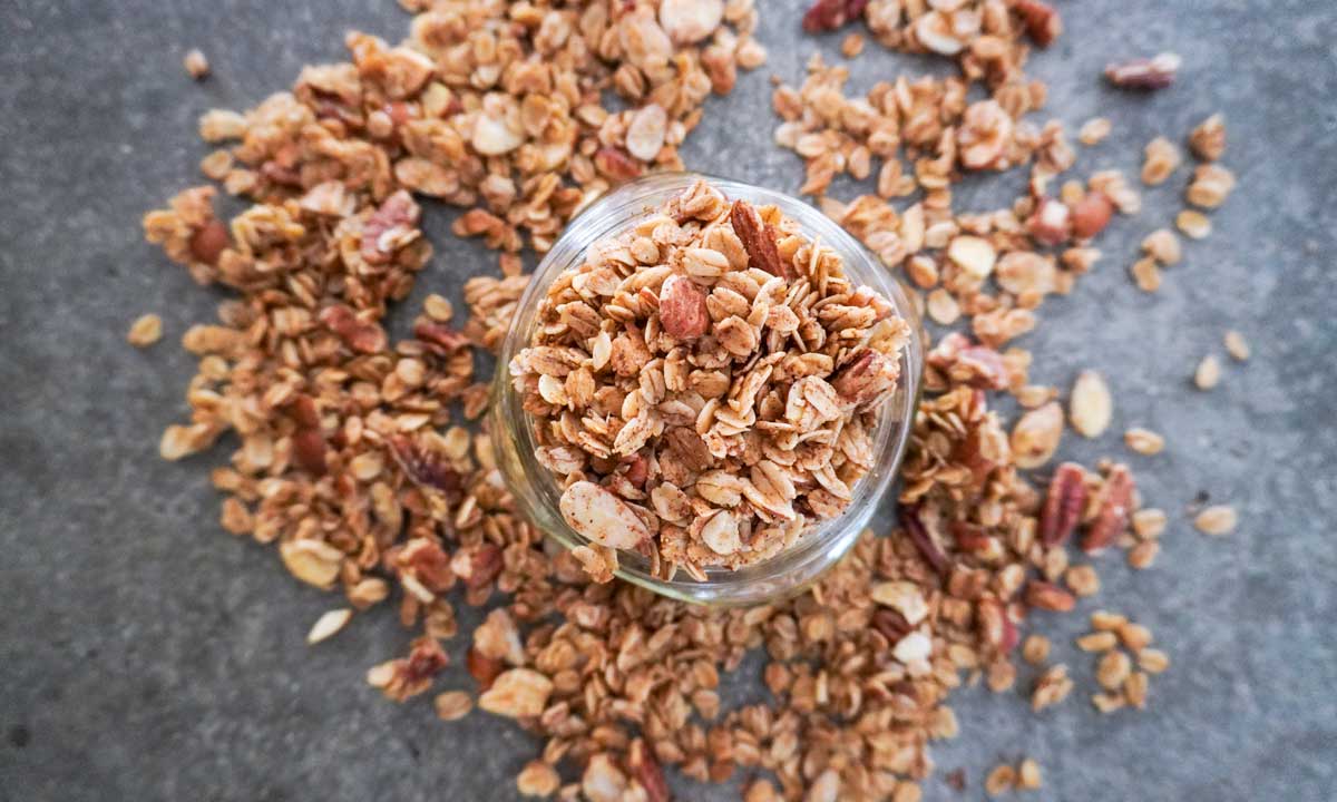 top view of granola in a glass jar on concrete countertop