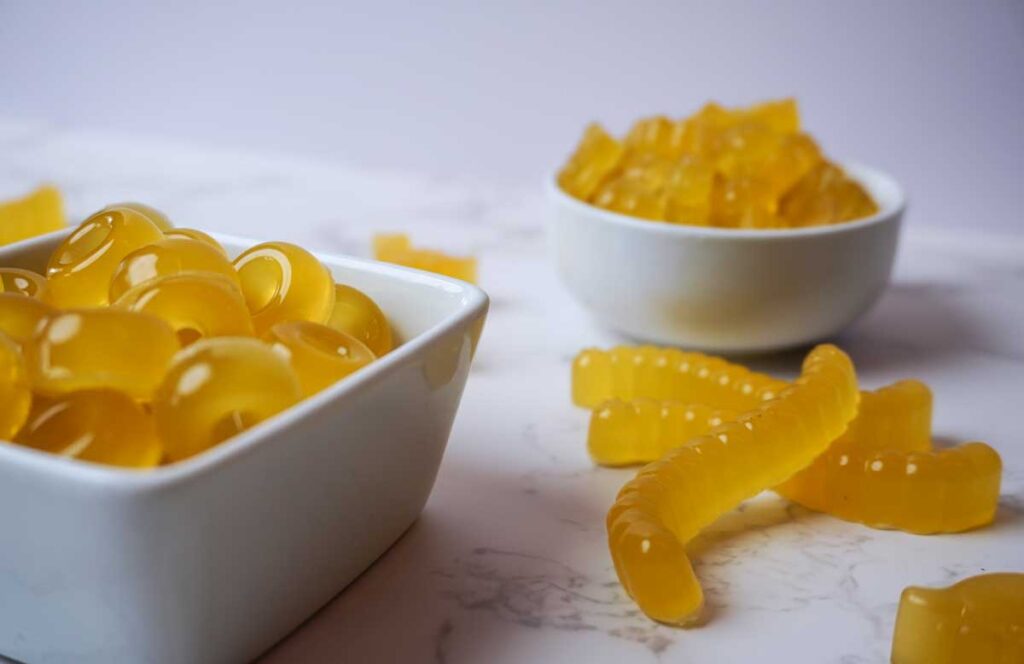 Two white bowls of homemade fruit snacks with fruit gummy worms