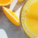 homemade gatorade in a glass with orange slices on the countertop