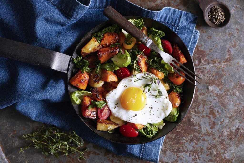 breakfast hash and over easy egg in a cast iron skillet