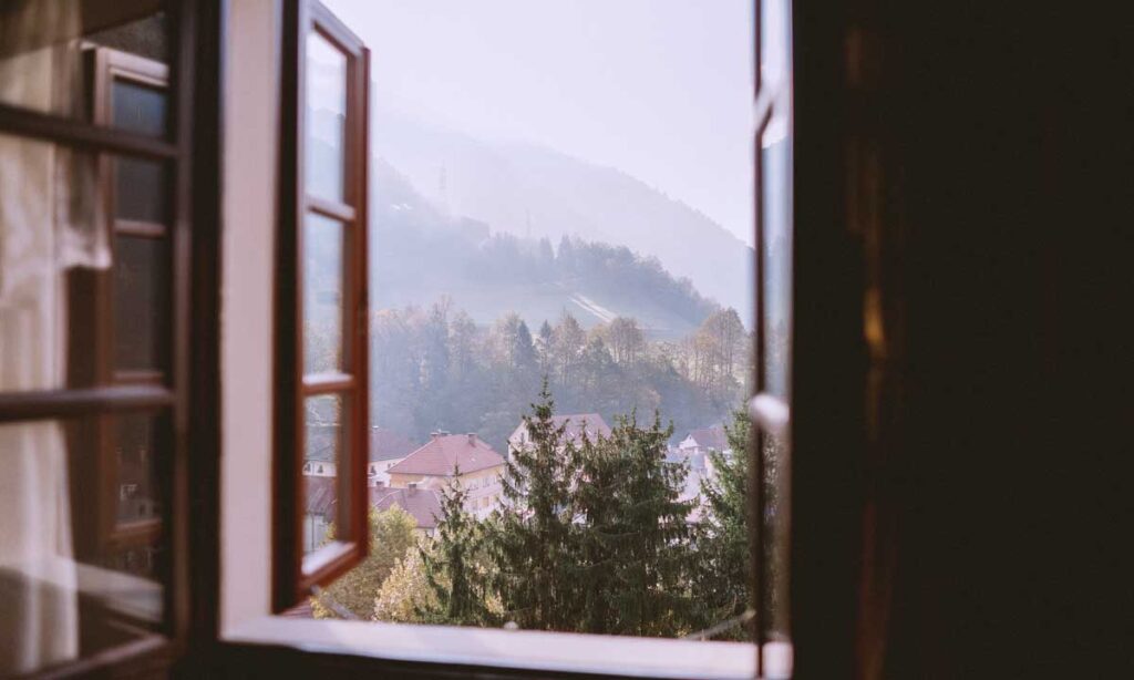 view of open window looking out to the mountains and fresh air