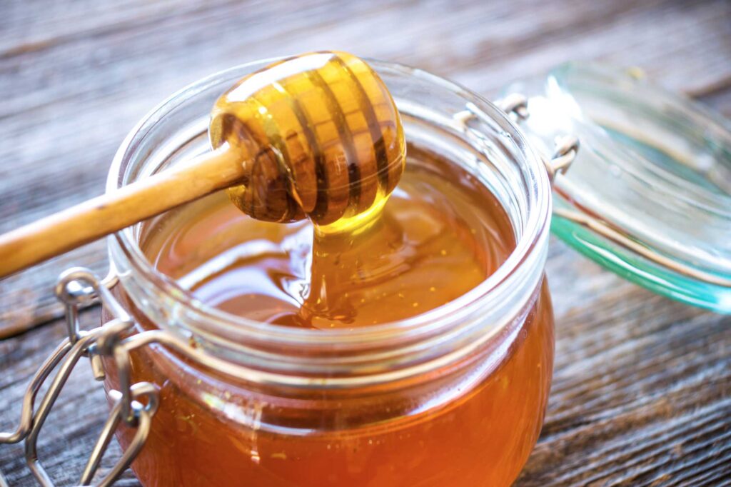 raw honey in a glass jar