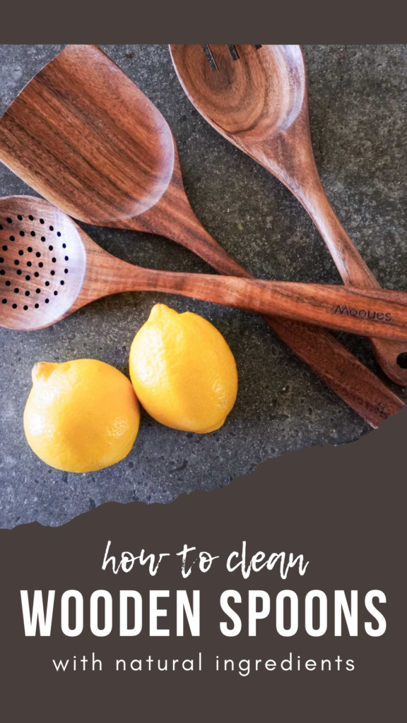 close up top view of three wooden spoons and two lemons on a concrete countertop. Text "how to clean wooden spoons with natural ingredients"