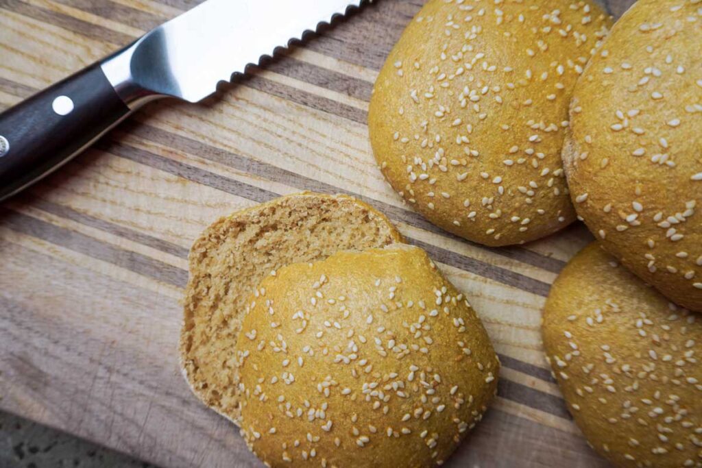 Fresh milled flour hamburger buns with a bread knife