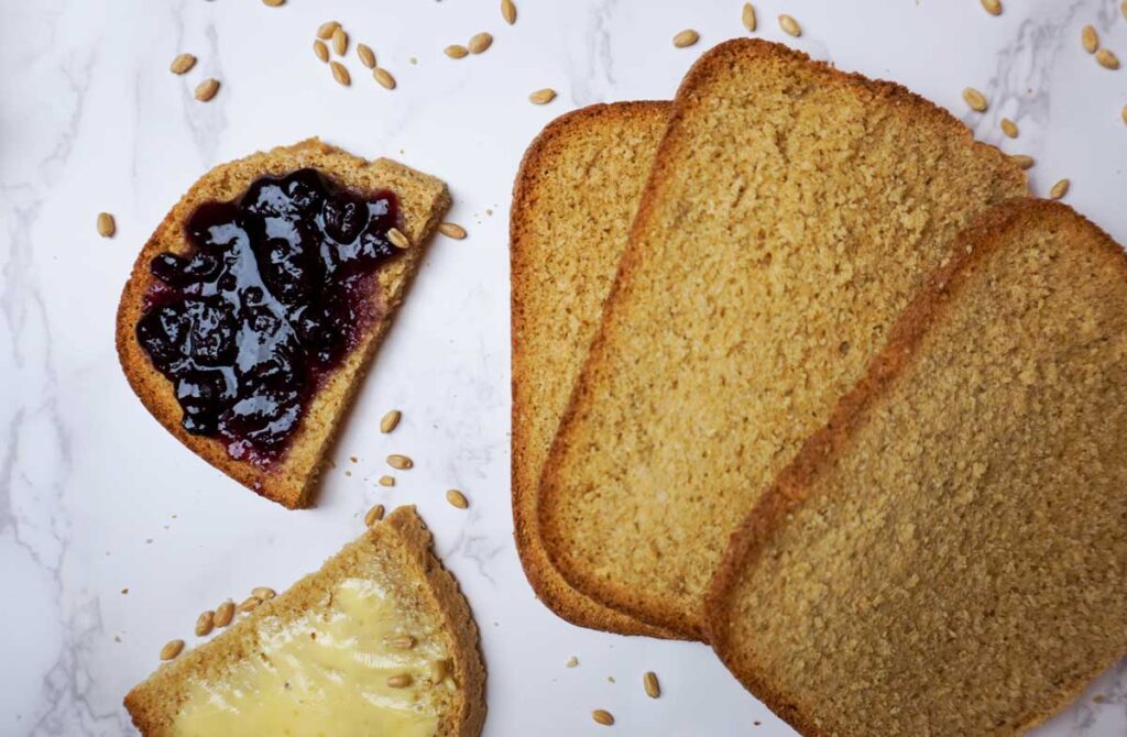 Slices of fresh whole wheat bread with butter and blueberry jam