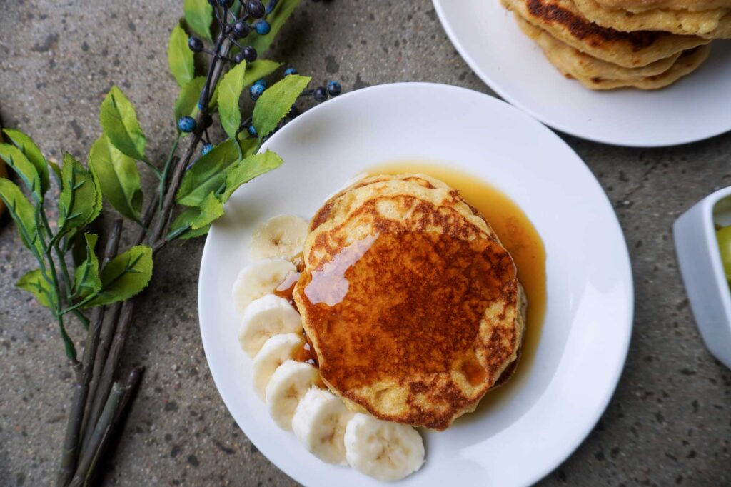 Freshly made healthy pancakes with syrup and banana slices