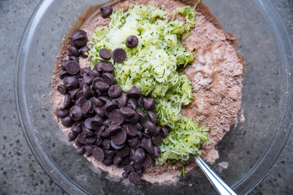 Top view of a bowl with chocolate zucchini muffin ingredients