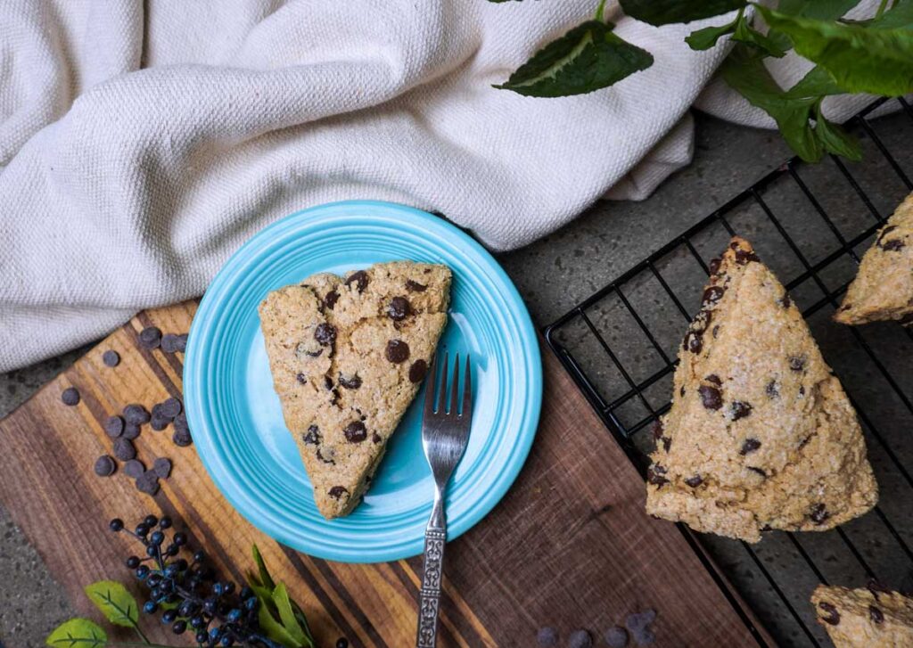 Fresh milled chocolate chip scones on a blue plate and cooling rack