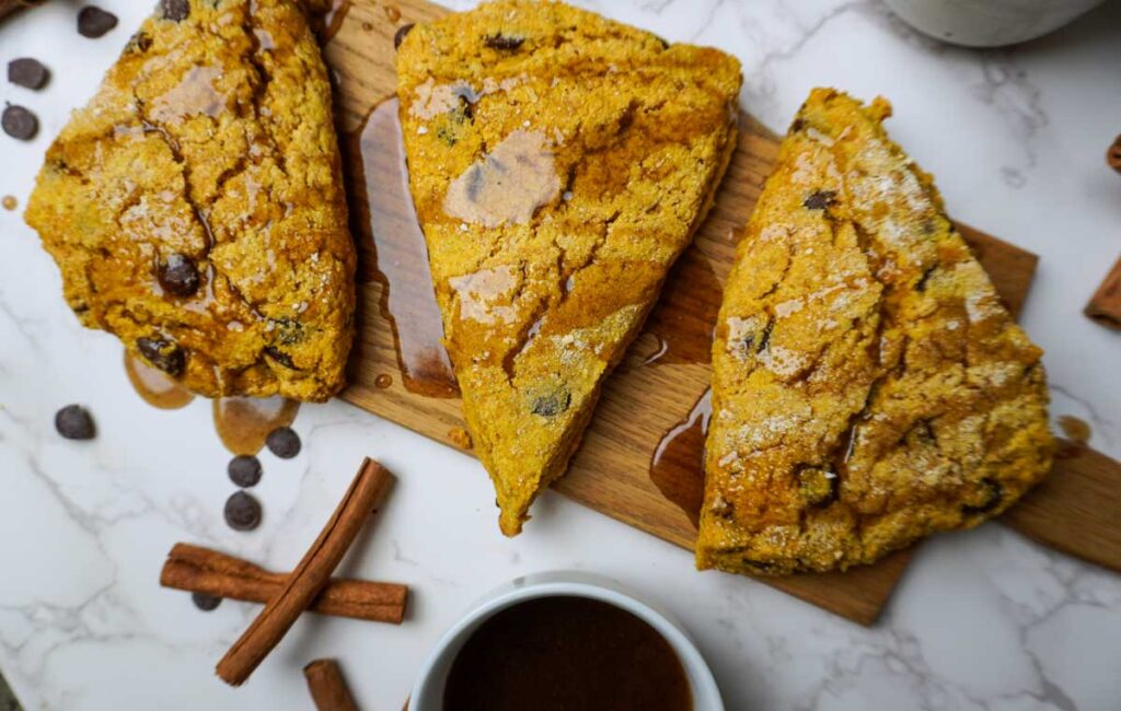 Top view of three pumpkin chocolate chip scones with maple glaze