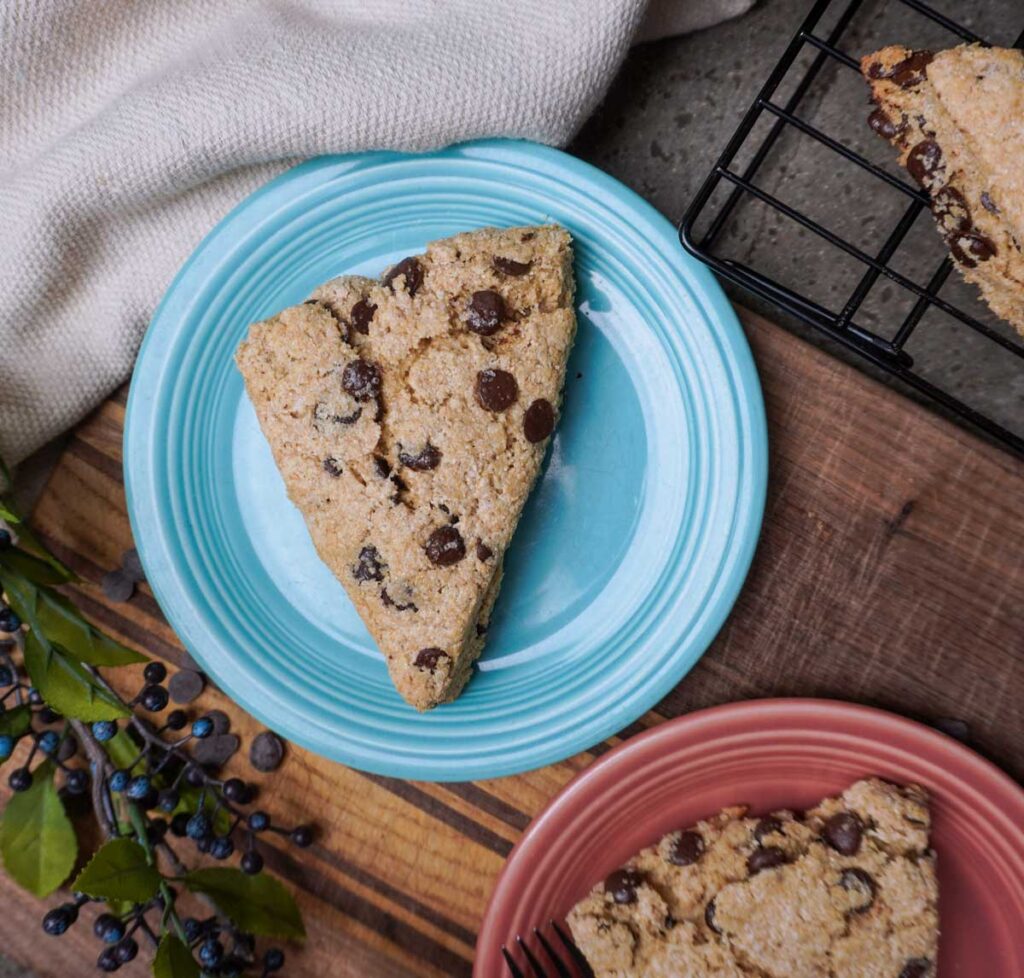Fresh milled chocolate chip scones on two colorful plates.